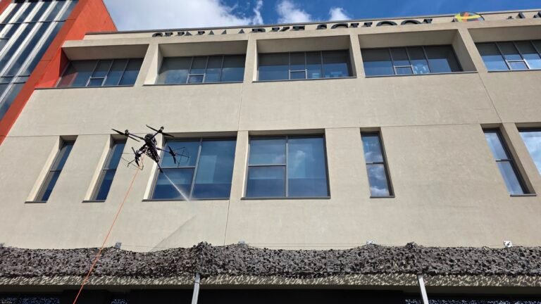 DRONICLE Drone cleaning a painted wall with windows, leaving no stain or dust behind