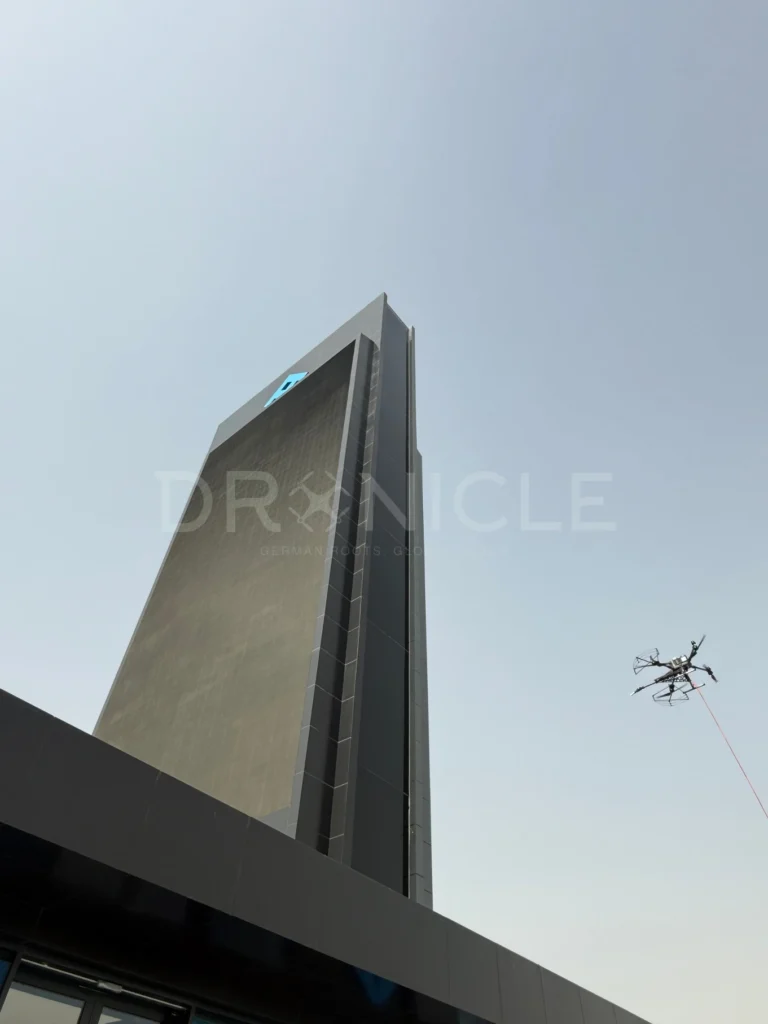 DRONICLE’s drone precision-cleaning an LED billboard, removing dust and grime to enhance visibility and performance.